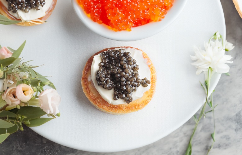 Black caviar served with potato and cream, photo by Gourmet Food Store