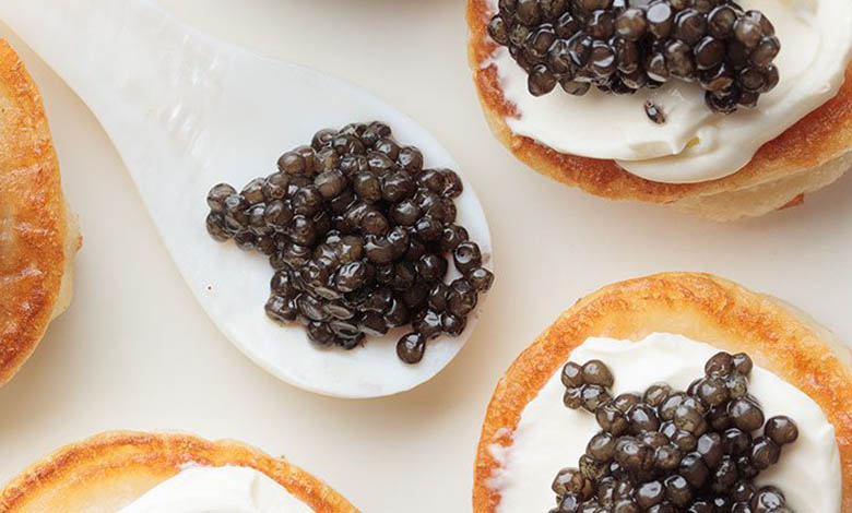 Premium black caviar served with blini and cream, photo by Gourmet Food Store